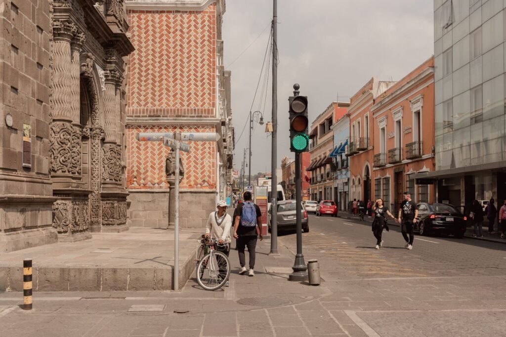 Urban street in Puebla, Mexico with people walking amidst historic architecture.
