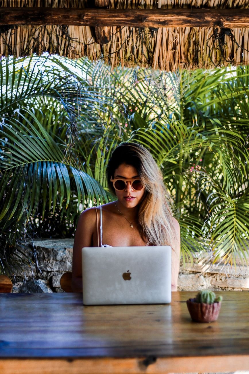 woman using her laptop on a wooden table
