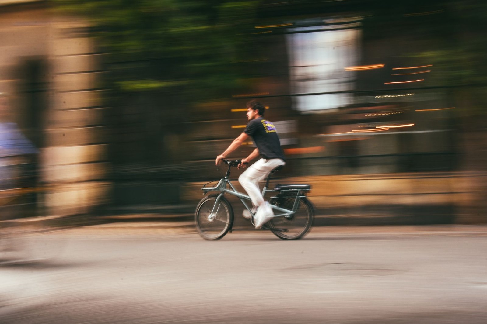 man in t shirt riding bicycle on street