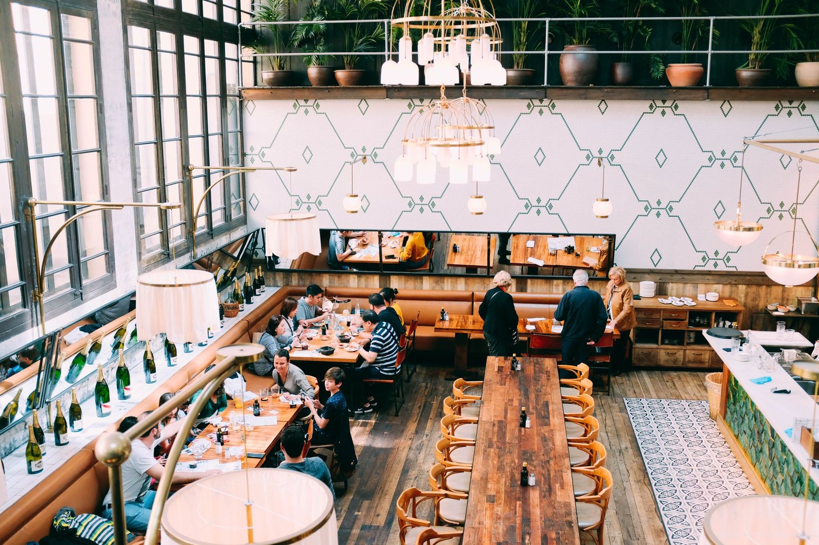 People dining at a stylish restaurant with wooden tables