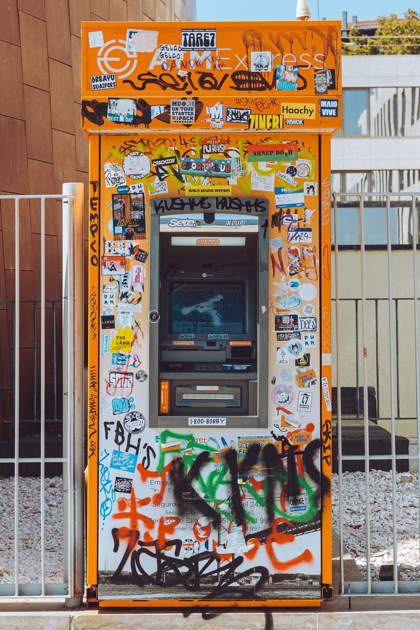 a atm machine with graffiti on it