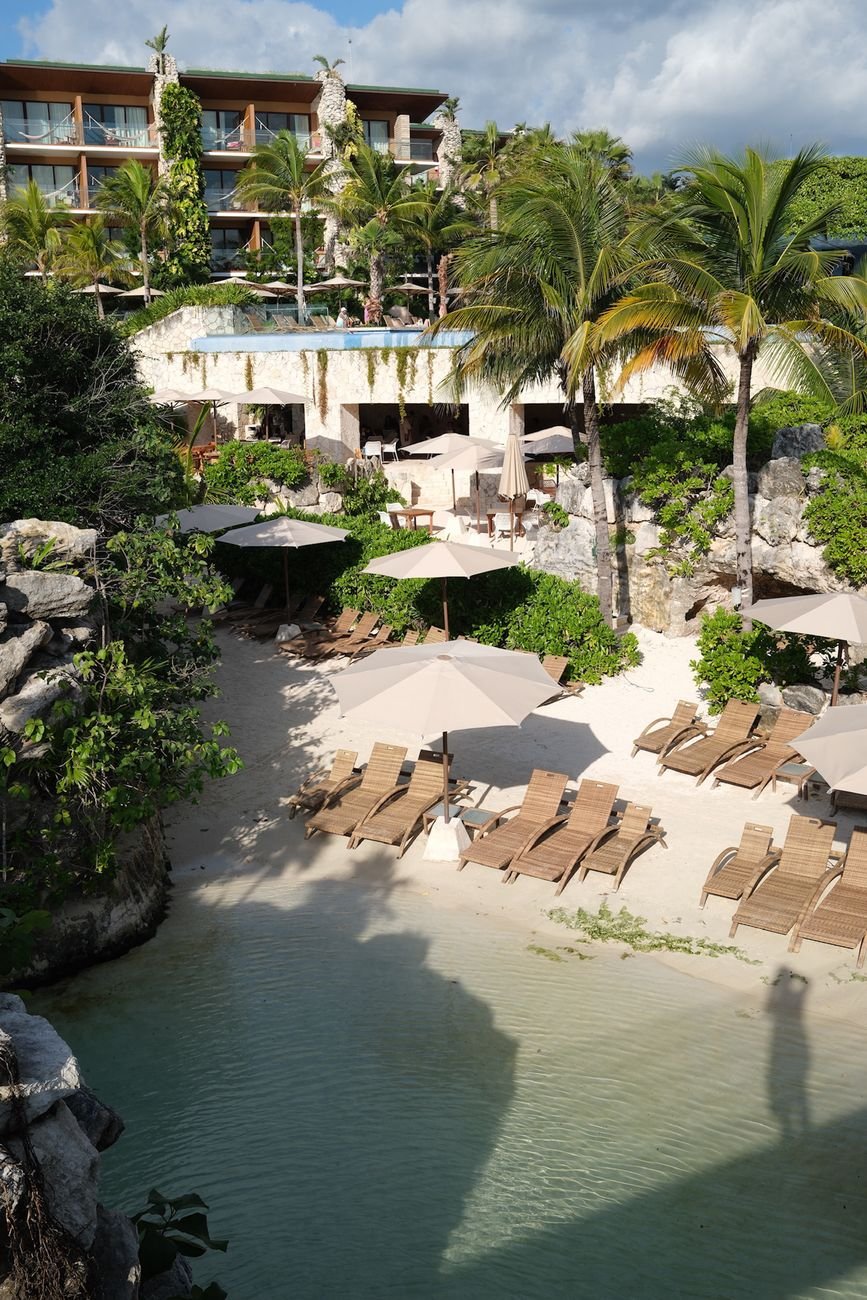 Luxury beach resort in Tulum, Mexico with palm trees and sun loungers