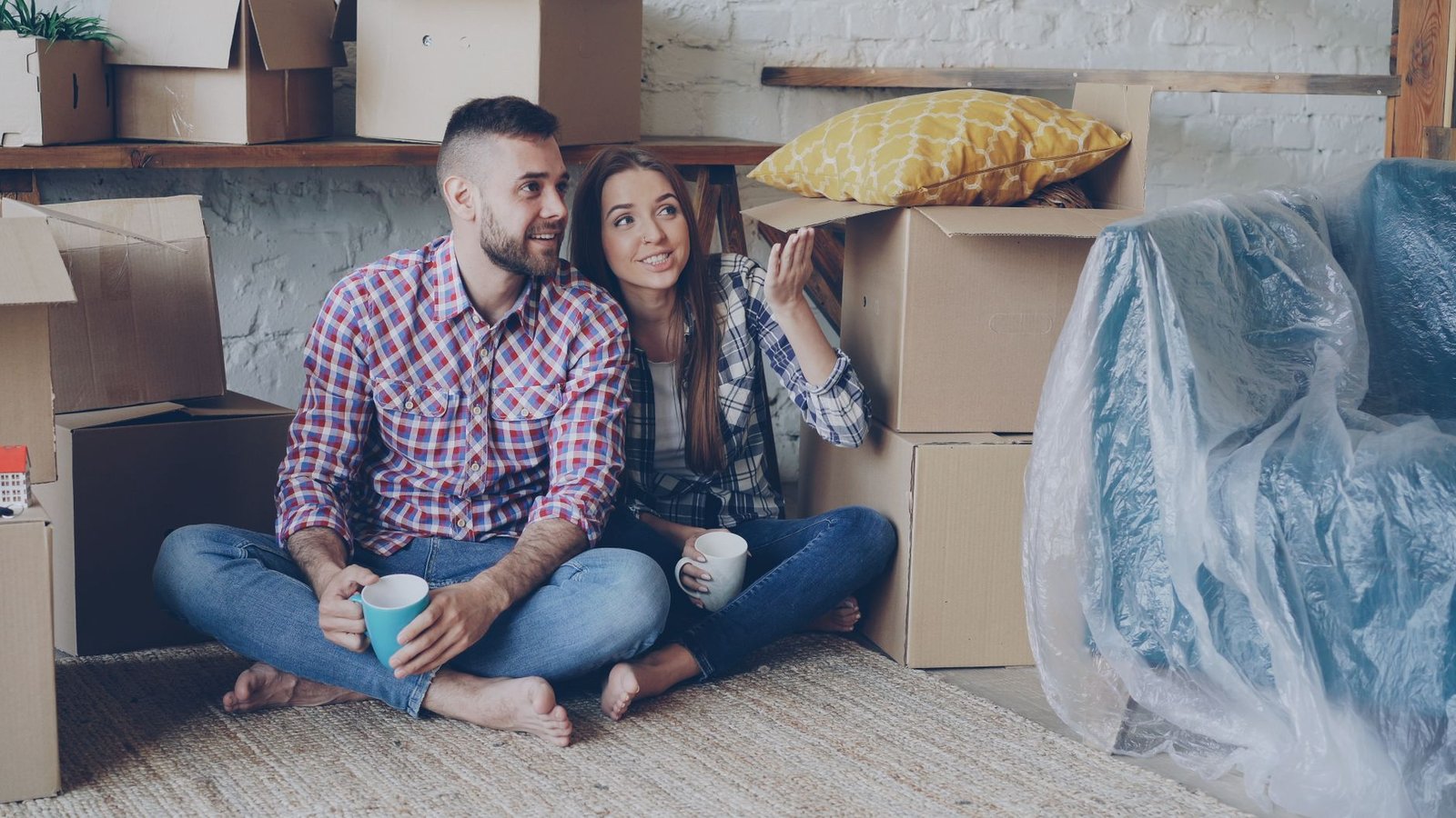 young couple relaxing among moving boxes at home