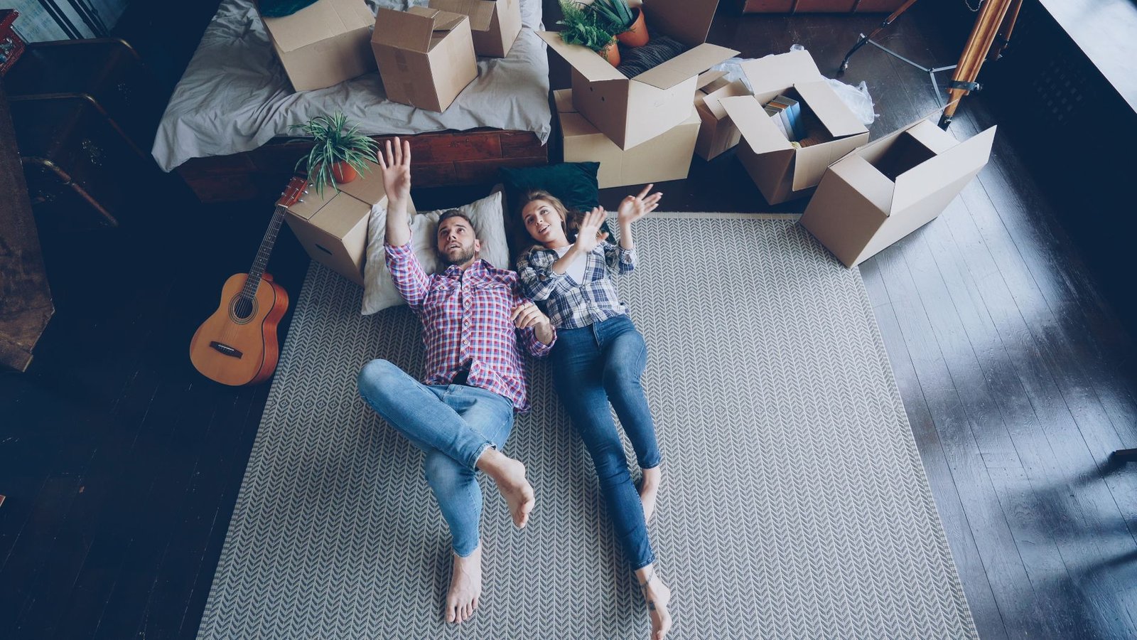 couple relaxing in new home with moving boxes