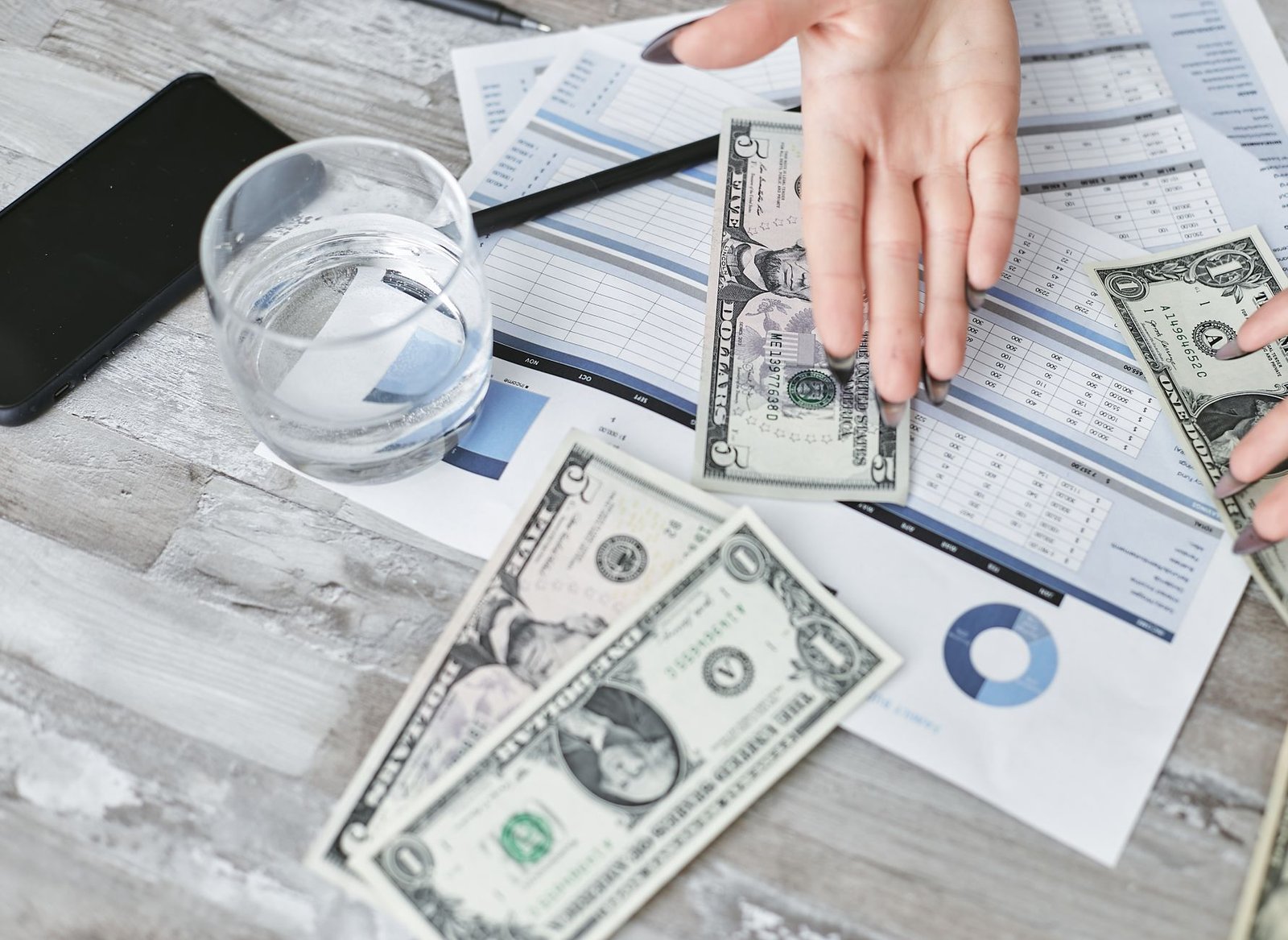 Financial planning documents with dollar bills emphasizing budgeting