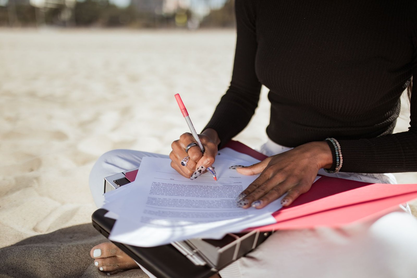 woman writing on a paper while at the beach
