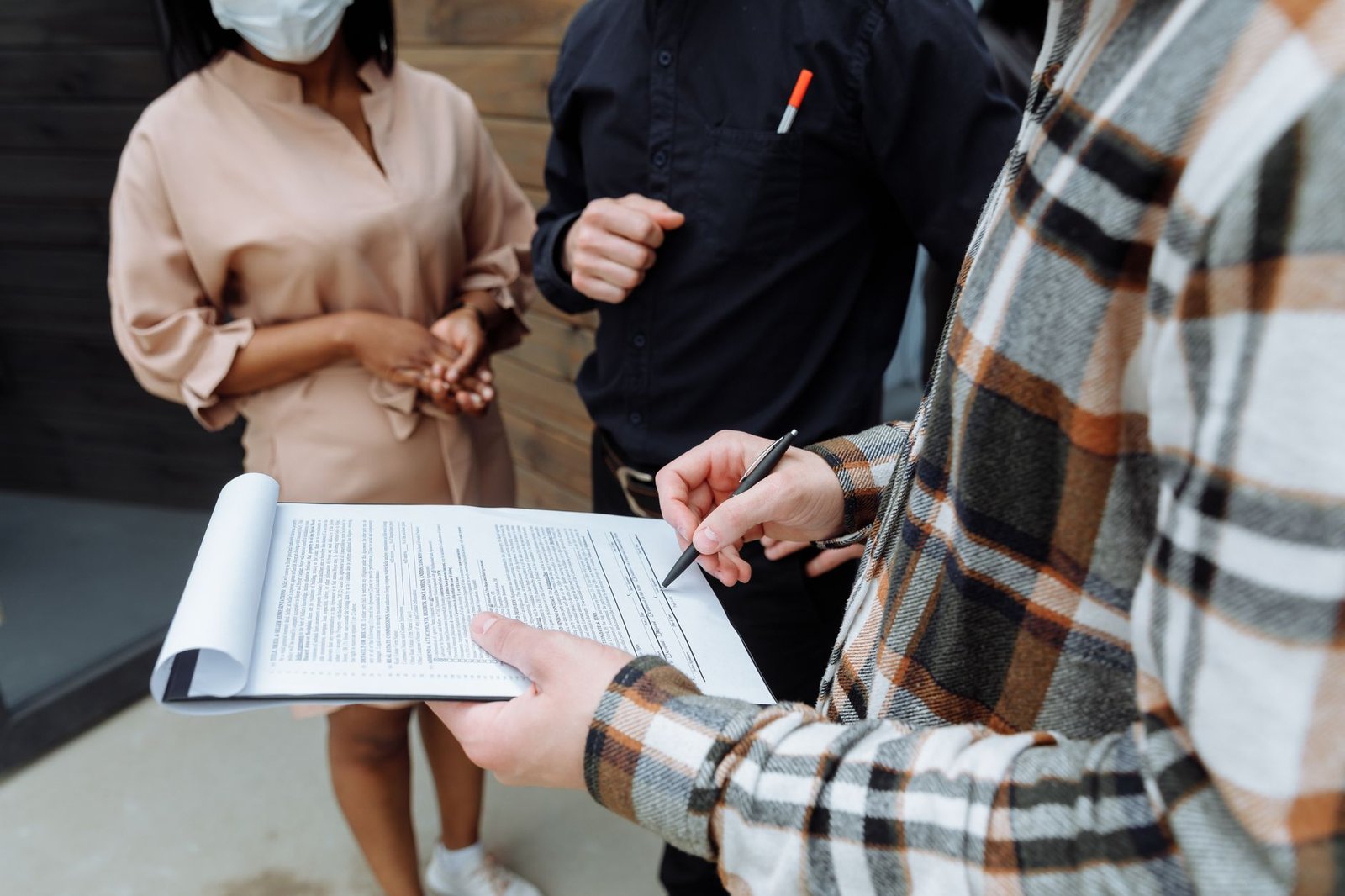 Person signing a rental contract document in an office