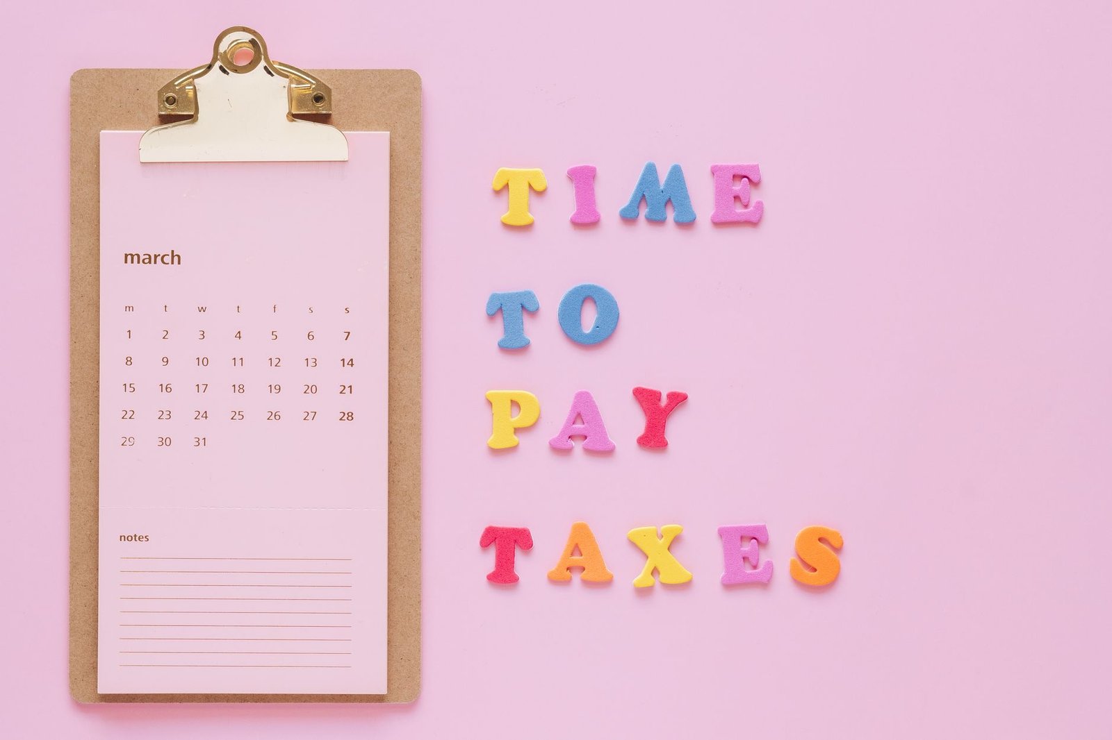 time to pay taxes sign by clipboard calendar
